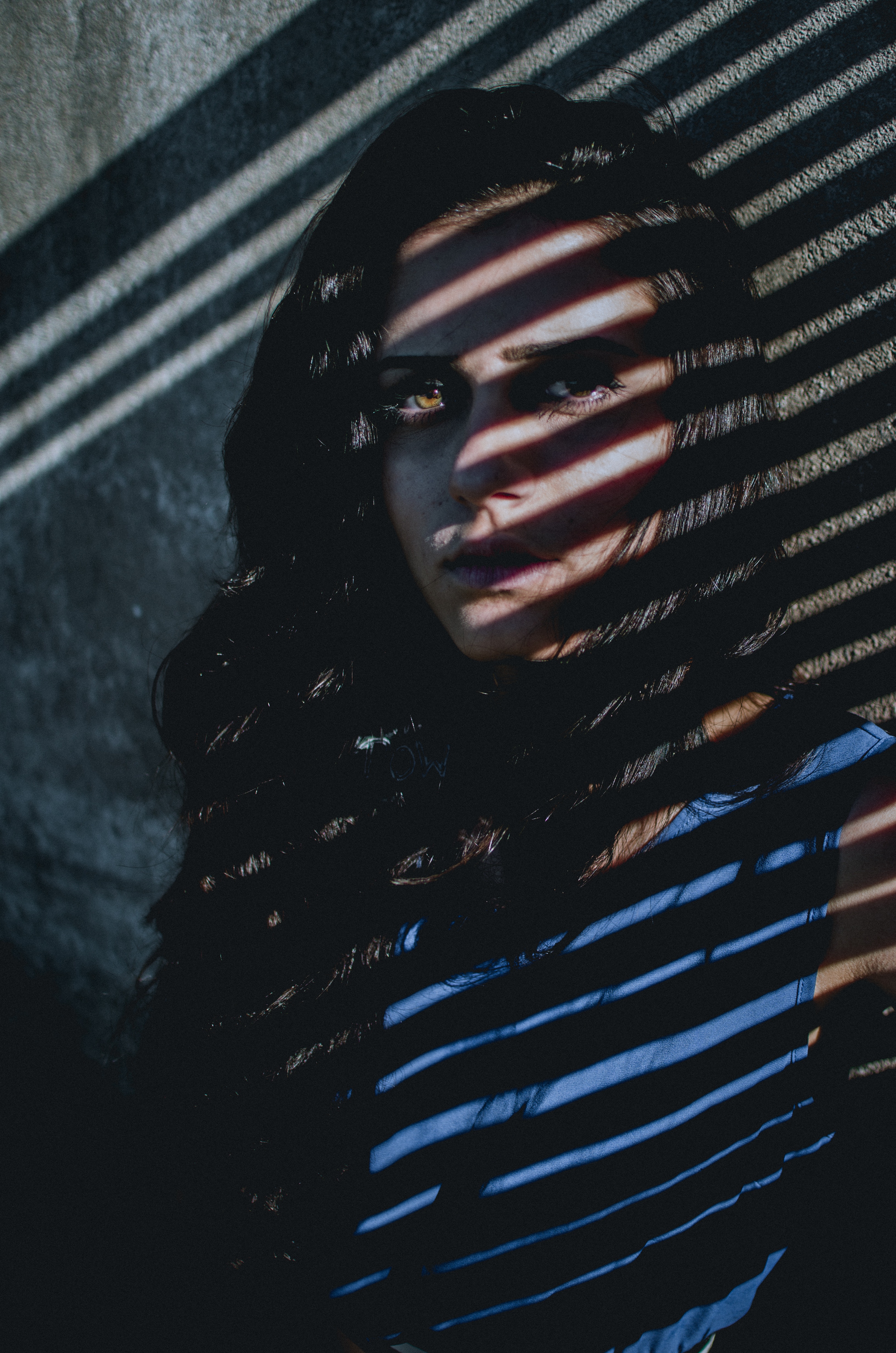 girl in shadows of blinds